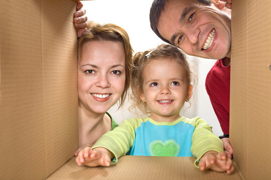 Happy Family Looking Through A Cardboard Box