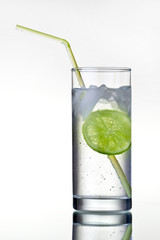 Glass of gin and tonic with ice and lime.