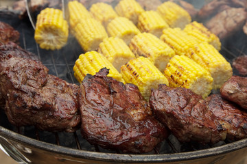 Meat and corn on coals