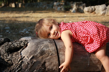 portrait de bébé fille se reposant sur un tronc d'arbre © choucashoot