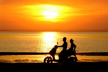 Obraz na płótnie Canvas Sylwetki dwóch młodych ludzi wyjeżdża na skuterze na zachodzie słońca