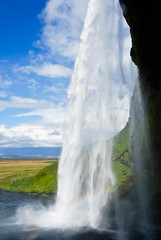 waterfall in a green landscape in Iceland