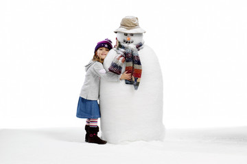 Isolated young girl and her snowman