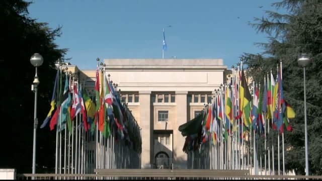 rows of international flags at UN entry in Geneva