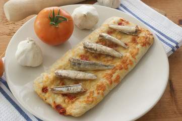 stone oven backed pizza with anchovy, tomato and garlic