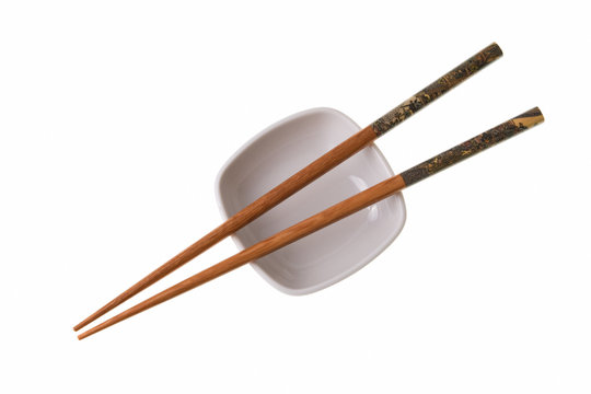 Wooden chopsticks on white saucer