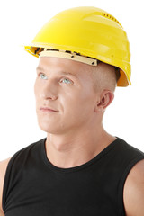 Young handsome builder in yellow helmet.