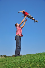father throwing his son in the air and catching him