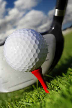 Golf club and ball in grass