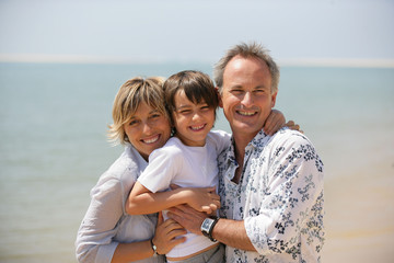 homme et femme avec un petit garçon au bord de la mer