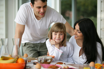 Couple prenant leur petit déjeuner en terrasse avec une enfant