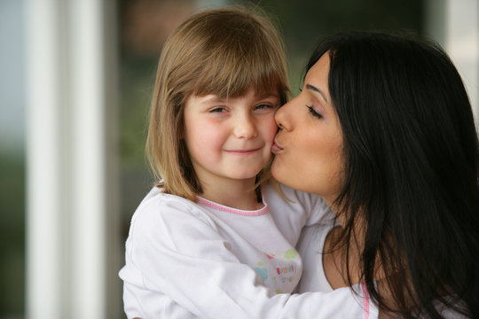 Portrait d'une femme embrassant une petite fille sur la joue