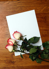 Naklejka na ściany i meble roses and blank paper on table
