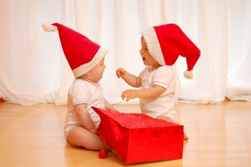 Zwei Kinder packen ein X-Mas Geschekn aus