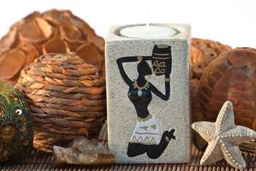 Isolated indian candlestick with sea star and bracelet on mat