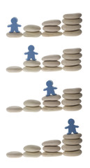 Series of figurine on different stacks of pebbles isolated