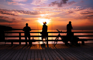Fototapeta na wymiar Trzy rybacki o zachodzie słońca