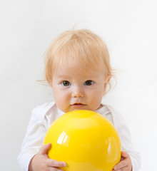 Fototapeta na wymiar Baby girl with bright yellow ball