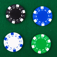 Casino chips each different color on green felt