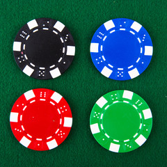 Naklejka premium Casino chips each different color on green felt