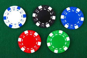 Casino chips each different color on green felt