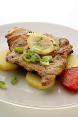 grilled carp fillet on organic potato with lemon and tomato