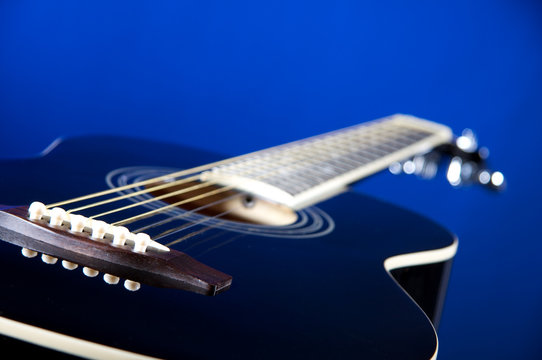 Black Acoustic Guitar On Blue