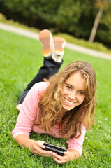 Teenager laying on grass texting