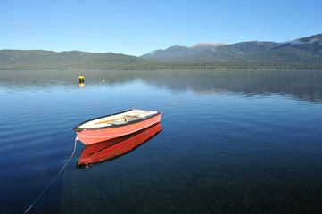 Fototapeta na wymiar Red boat on the lake Te Anau in south New Zealand