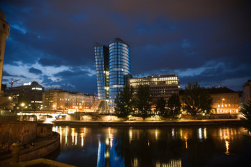 Fototapeta na wymiar Szklana fasada z Uniqua Tower w Wiedniu świeci w nocy