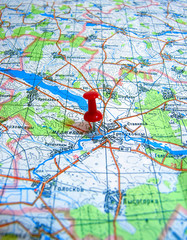 Red pushpin marking a location on a road map.