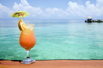A refreshing tropical drink, with an island in the background