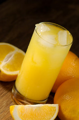 Oranges and orange juice in a glass on a dark background