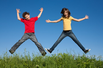 Fototapeta na wymiar Kids jumping on green meadow