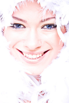 laughing young woman with white boa over her face