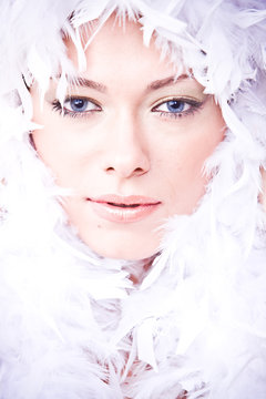 closeup portrait of young woman with white boa over her face