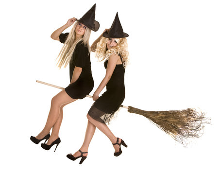 Halloween witch blond in black dress and hat on broom.