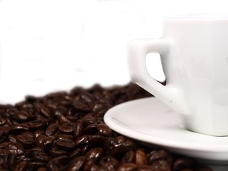 White cup of coffe on coffee beans background