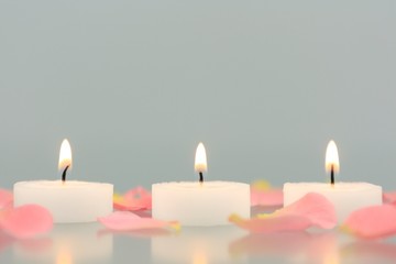 Kerzen mit Rosenblüten