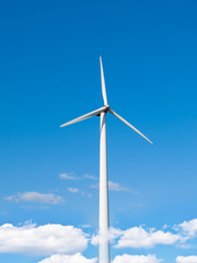 Fototapeta premium Wind power station - wind turbine against the blue sky