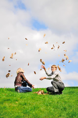 Happy couple enjoying the falling leaves