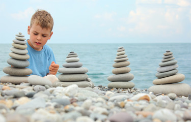boy and stone stacks on pebble beach