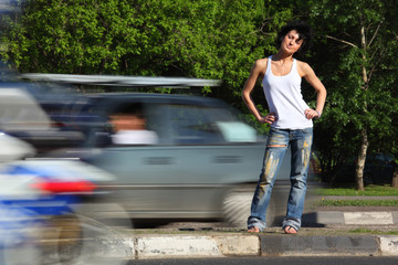 girl stands on road among cars