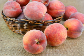 Fototapeta na wymiar Fresh Peaches in and around a basket.