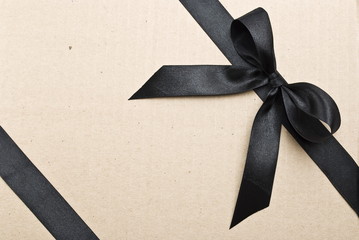 Black satin ribbon on cardboard background