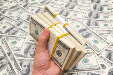 Fototapeta premium Hand holding american dollars against money background