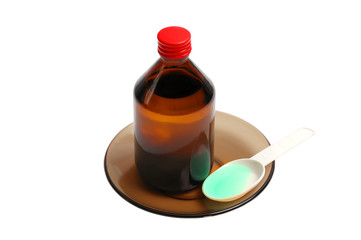 Bottle with a medicine and a spoon on a black saucer it is isola