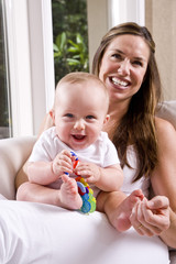 Mother with six month old baby playing on lap