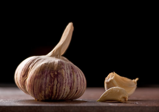 Ripe garlic head with a couple of peeled cloves