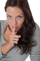 Fototapeta premium Beautiful woman expressing silence, finger on lips
